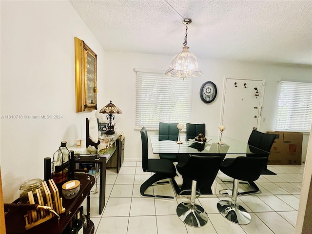 dining room featuring a chandelier, a textured ceiling, and light tile patterned flooring