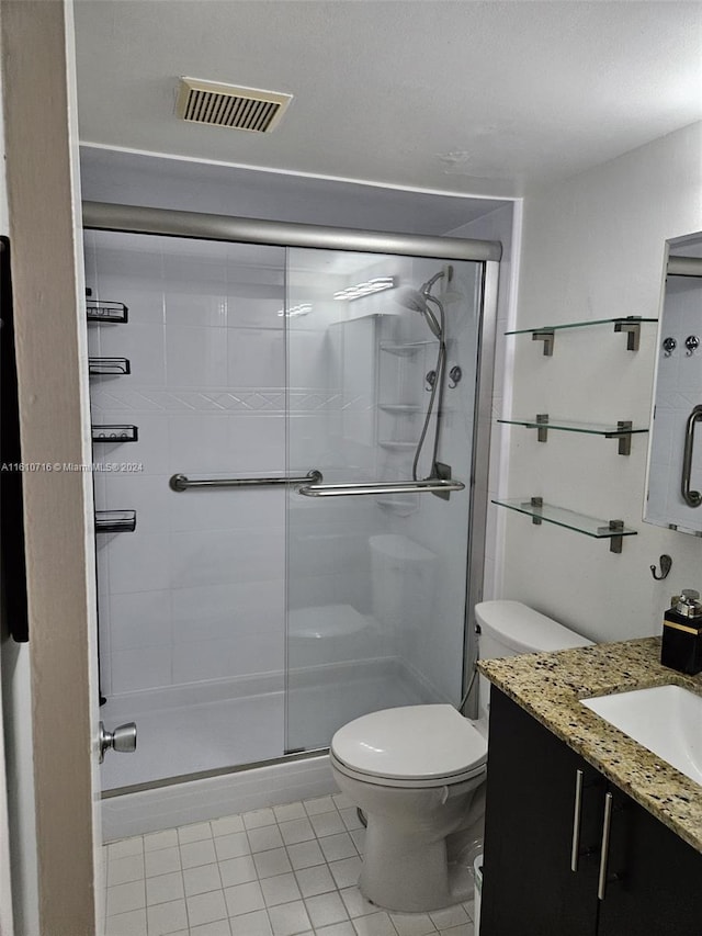 bathroom with walk in shower, tile patterned flooring, vanity, and toilet