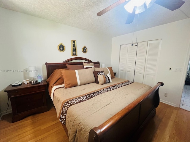 bedroom featuring hardwood / wood-style flooring, ceiling fan, a textured ceiling, and a closet