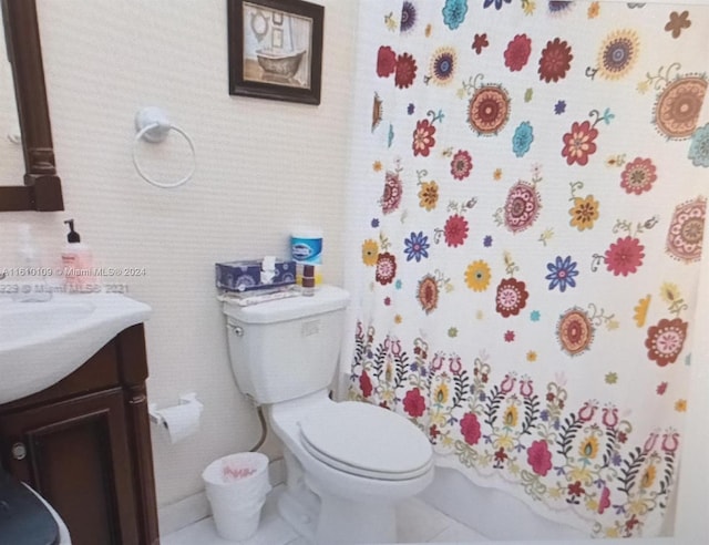 bathroom with tile flooring, vanity, and toilet