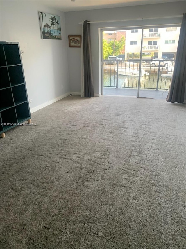 carpeted spare room featuring a water view