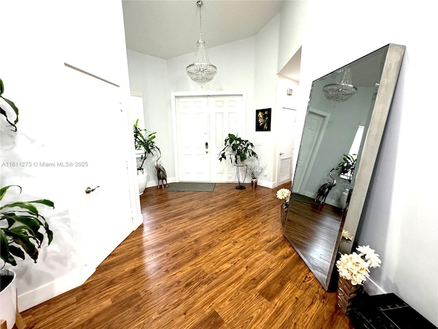 foyer with high vaulted ceiling, baseboards, and wood finished floors