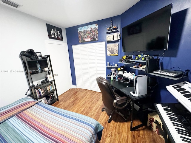 bedroom featuring wood finished floors and visible vents