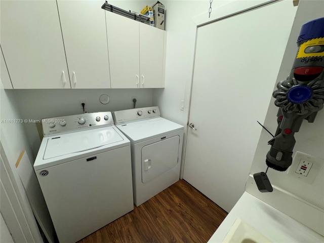 clothes washing area with cabinet space, washing machine and dryer, and dark wood-style flooring