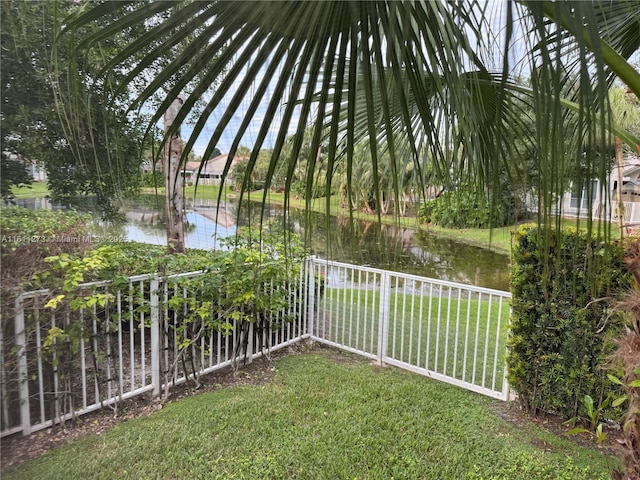 view of yard with a water view and fence