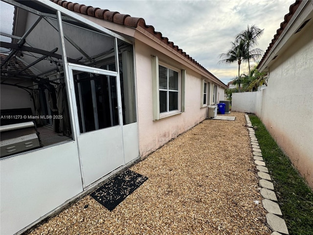 view of property exterior with a fenced backyard, a tiled roof, and stucco siding