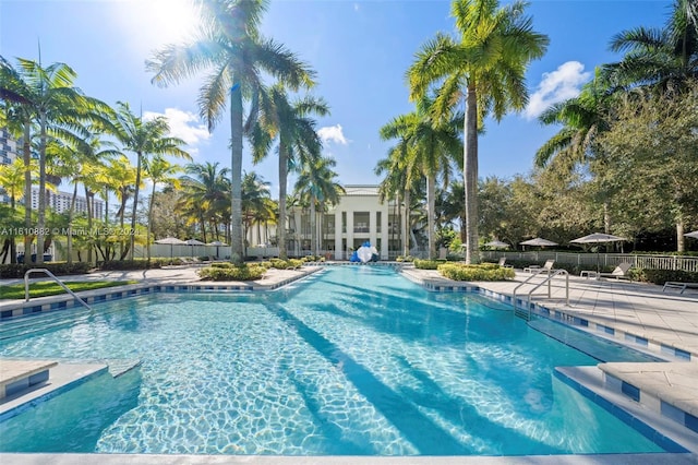 community pool with a patio and fence