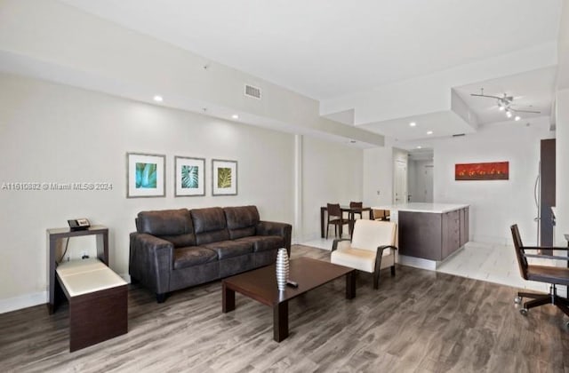 living room featuring ceiling fan and light hardwood / wood-style flooring