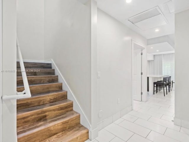 stairway featuring baseboards, recessed lighting, attic access, and tile patterned floors