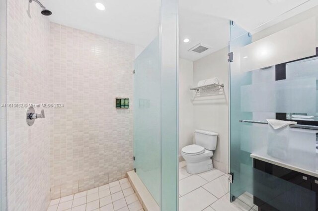 bathroom featuring walk in shower, tile flooring, and toilet