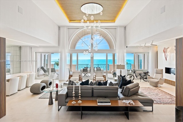 living room featuring a towering ceiling and a chandelier