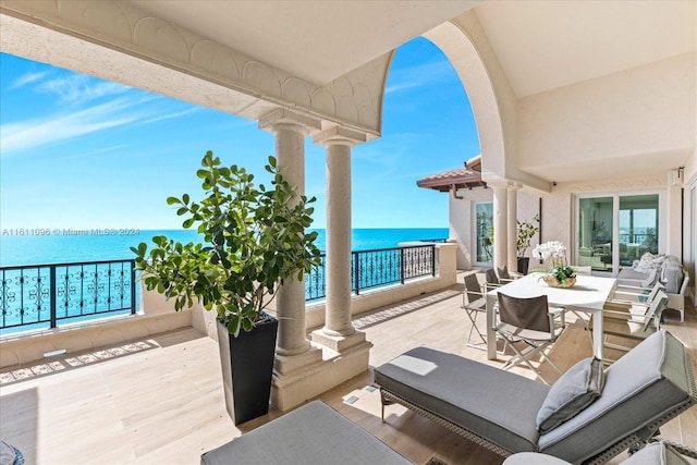 view of patio with a balcony and a water view