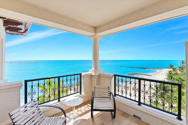 balcony featuring a water view and a view of the beach