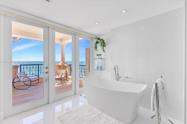 bathroom featuring tile patterned floors, a water view, and french doors