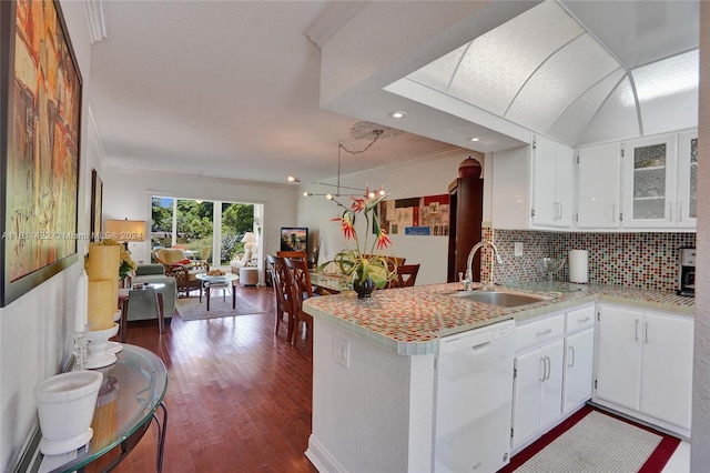 kitchen with dishwasher, kitchen peninsula, white cabinets, backsplash, and sink