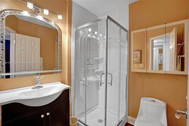 bathroom with a shower with door, vanity, and toilet