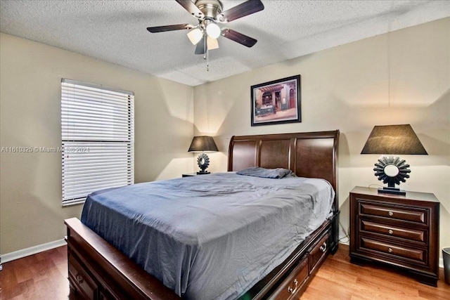 bedroom featuring a textured ceiling, light hardwood / wood-style floors, and ceiling fan