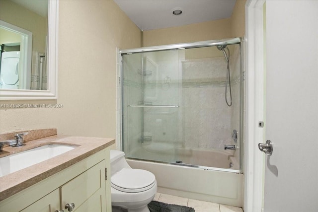 full bathroom with enclosed tub / shower combo, tile patterned floors, washer / clothes dryer, toilet, and vanity