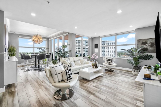 living room featuring crown molding, recessed lighting, light wood-style floors, a chandelier, and baseboards