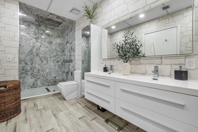 bathroom with toilet, a marble finish shower, visible vents, and a sink