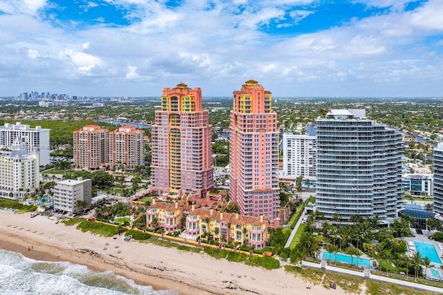 drone / aerial view featuring a view of city, a water view, and a view of the beach