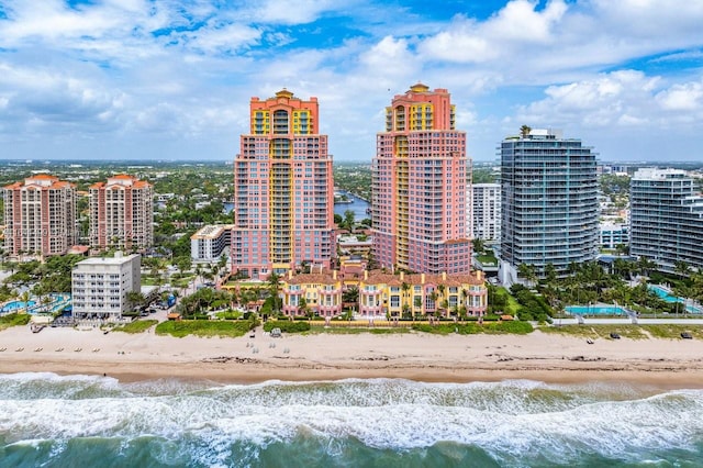 drone / aerial view with a water view, a beach view, and a city view