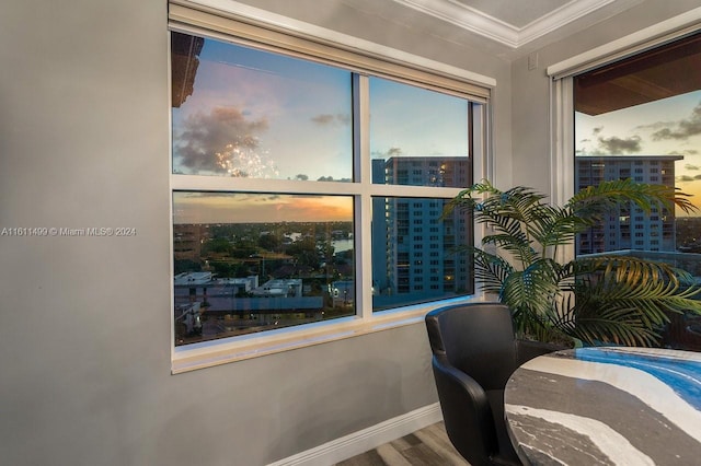 office space with a view of city, ornamental molding, wood finished floors, and baseboards