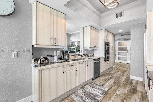 kitchen with ornamental molding, stainless steel dishwasher, double oven, wood-type flooring, and sink