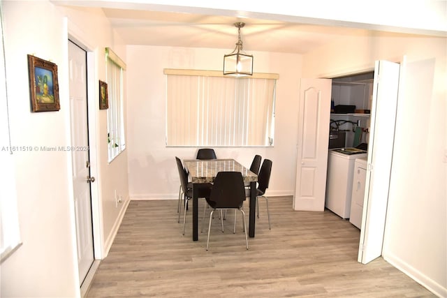 dining room with washing machine and clothes dryer and light hardwood / wood-style flooring