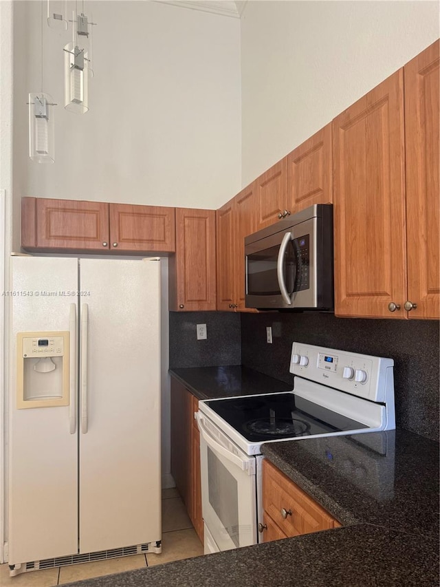 kitchen with backsplash, light tile patterned floors, and white appliances