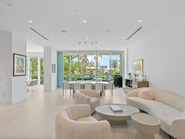 living room featuring a healthy amount of sunlight, a wall of windows, and light tile floors