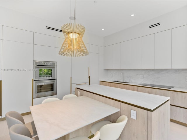 16500 Collins Ave Unit Th-8, Sunny Isles Beach, FL 33160 - kitchen featuring a sink, modern cabinets, stainless steel double oven, a breakfast bar area, and a center island