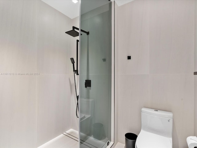 bathroom featuring a tile shower and toilet