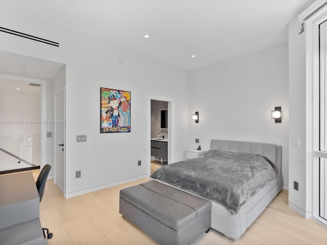 bedroom featuring ensuite bathroom and light wood-type flooring