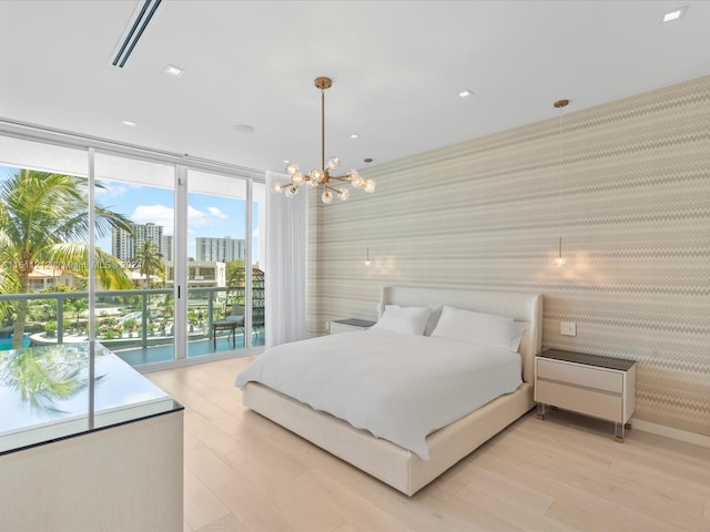 bedroom with light hardwood / wood-style floors and an inviting chandelier