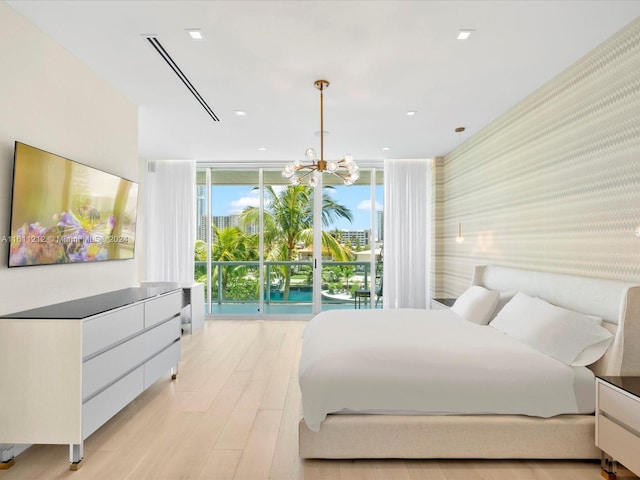 bedroom with light hardwood / wood-style flooring, floor to ceiling windows, and a chandelier