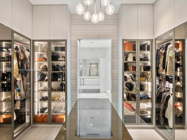 walk in closet featuring a chandelier