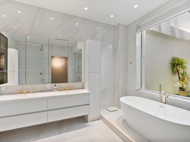 bathroom with tile floors, dual sinks, a healthy amount of sunlight, and vanity with extensive cabinet space