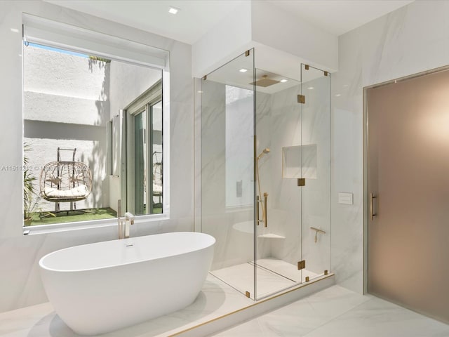 bathroom featuring a wealth of natural light, tile flooring, tile walls, and independent shower and bath