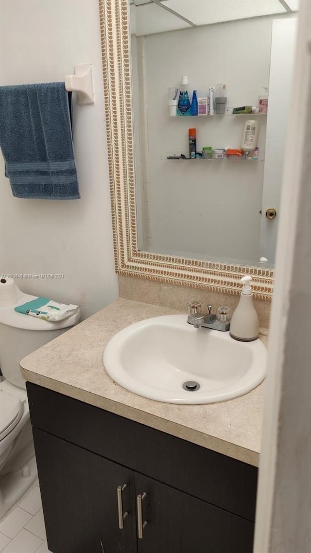 bathroom featuring tile floors, toilet, and vanity