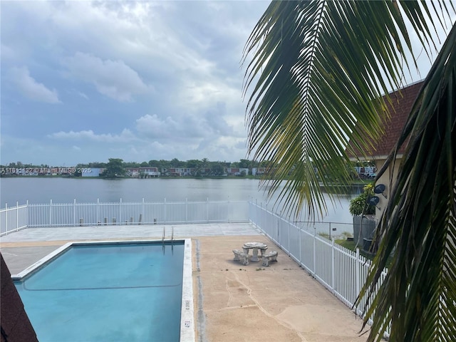 view of pool with a patio area and a water view