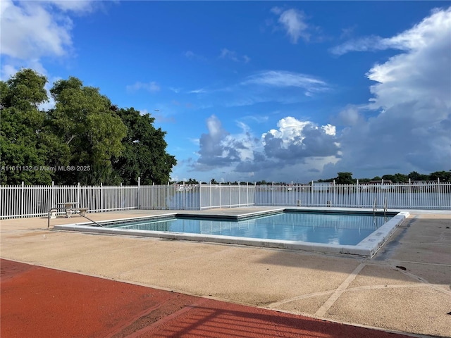 view of swimming pool with a patio area and a water view