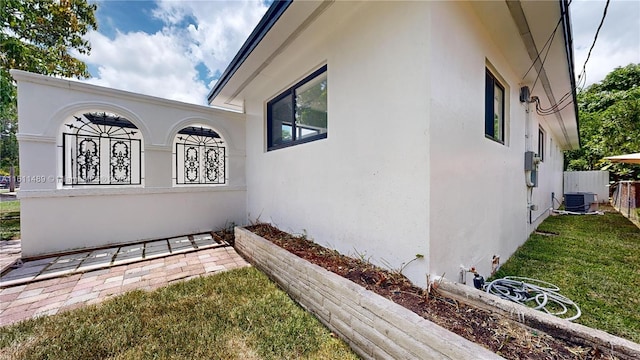 view of side of property featuring a yard and central air condition unit