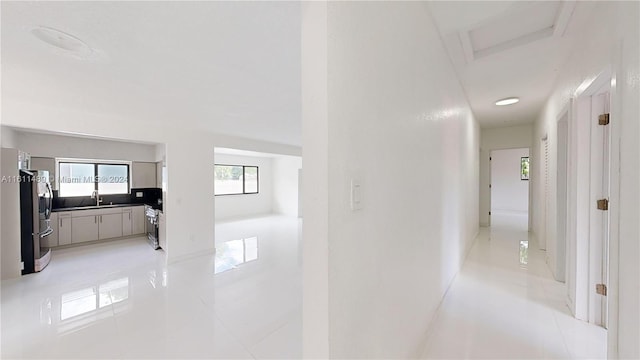 corridor with sink and light tile patterned floors