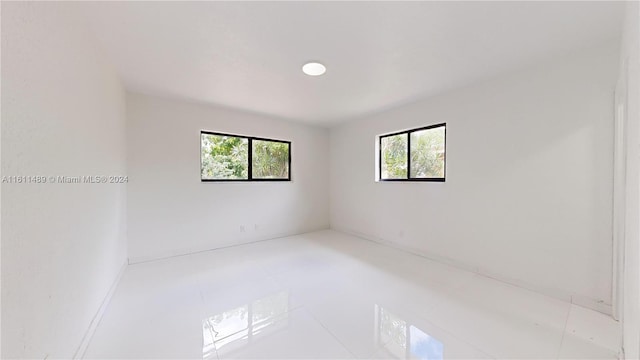 empty room featuring a healthy amount of sunlight and light tile patterned floors