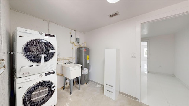 clothes washing area with stacked washer / drying machine, sink, and water heater