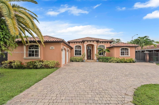 mediterranean / spanish-style house featuring a garage and a front yard