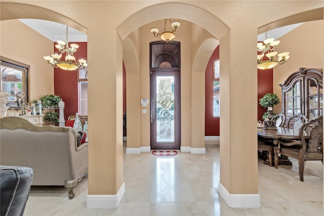 entrance foyer with a notable chandelier, tile flooring, and ornamental molding