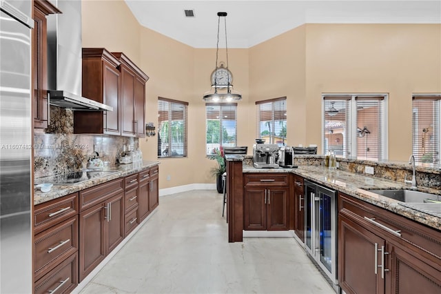 kitchen with tasteful backsplash, black electric cooktop, pendant lighting, light tile floors, and wall chimney range hood