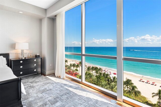 unfurnished bedroom featuring a view of the beach and a water view